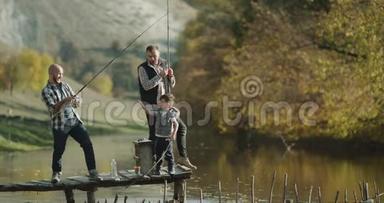 钓鱼时间为两个朋友和一个小男孩在晴天用钓鱼竿钓鱼。 4k